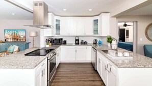 Eine moderne Küche mit weißen Schränken, Granit-Arbeitsplatten und Edelstahlgeräten.