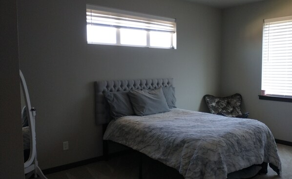 A bedroom with a bed, a window, and a chair. - 4-bedroom house in charming Coeur d'Alene with AC, WiFi, fitness room (Coeur d'Alene)