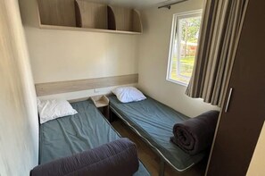A compact room with two single beds, a window with curtains, and a built-in shelf above the beds. - Louisiana, 6 people   (La Boissière-de-Montaigu)