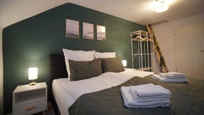 A bedroom with a bed, nightstands, and a wardrobe. - Charming half-timbered apartment with modern comfort, 110 sqm (Eltville am Rhein)