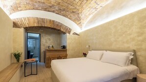 Un dormitorio con una cama grande, un escritorio de madera y un techo de ladrillo.