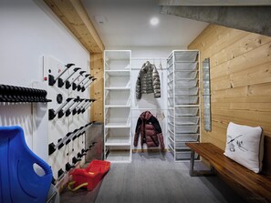 Um armazém com prateleiras para sapatos, um banco e um suporte na parede para casacos.