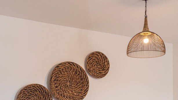 A bedroom with a bed, a wooden floor, and a hanging light fixture. - The Virginian Room @ Main Street Lofts (Victoria)