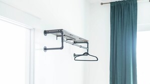 A room with a bench, a metal drying rack, and a green curtain. - The Darlington Room @ Main Street Lofts (Victoria)