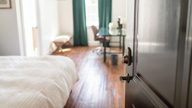 A hotel room with a bed, a desk, and a chair. - The Darlington Room @ Main Street Lofts (Victoria)