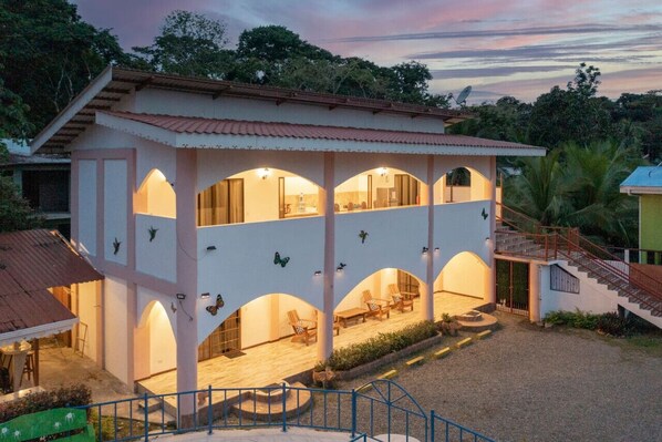 A two-story building with multiple balconies and a covered patio area.