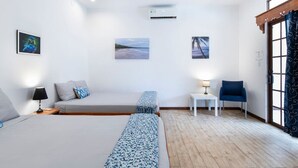 Ein Hotelzimmer mit einem Bett, zwei Nachttischen, einem Sessel und einem Fenster mit Vorhängen.