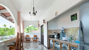 Uma cozinha moderna com frigorífico de aço inoxidável, cadeiras de madeira e uma mesa de jantar.