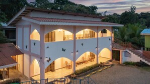 Um edifício de dois andares com várias varandas e um espaço de estar coberto.