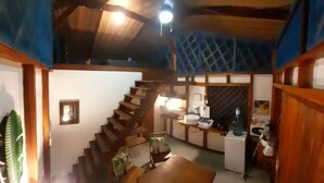 A compact kitchen with a wooden staircase, a dining area, and a small refrigerator. - La Casita Beachfront Hideaway | Pool Access (Manzanillo)