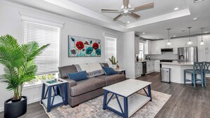 Un salon moderne avec un canapé, une table basse et un ventilateur de plafond.
