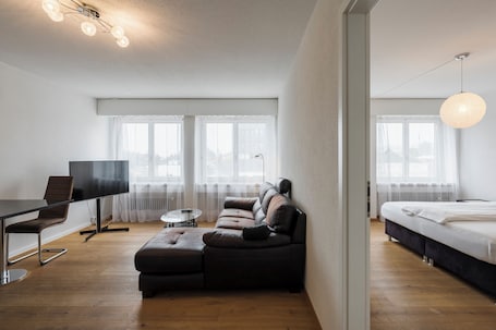 Deluxe tweepersoonskamer | Woonruimte | Een 22-inch flatscreentelevisie met kabelzenders