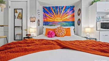 Un dormitorio con cama, mesita de noche, reloj de pared, espejo y puerta.