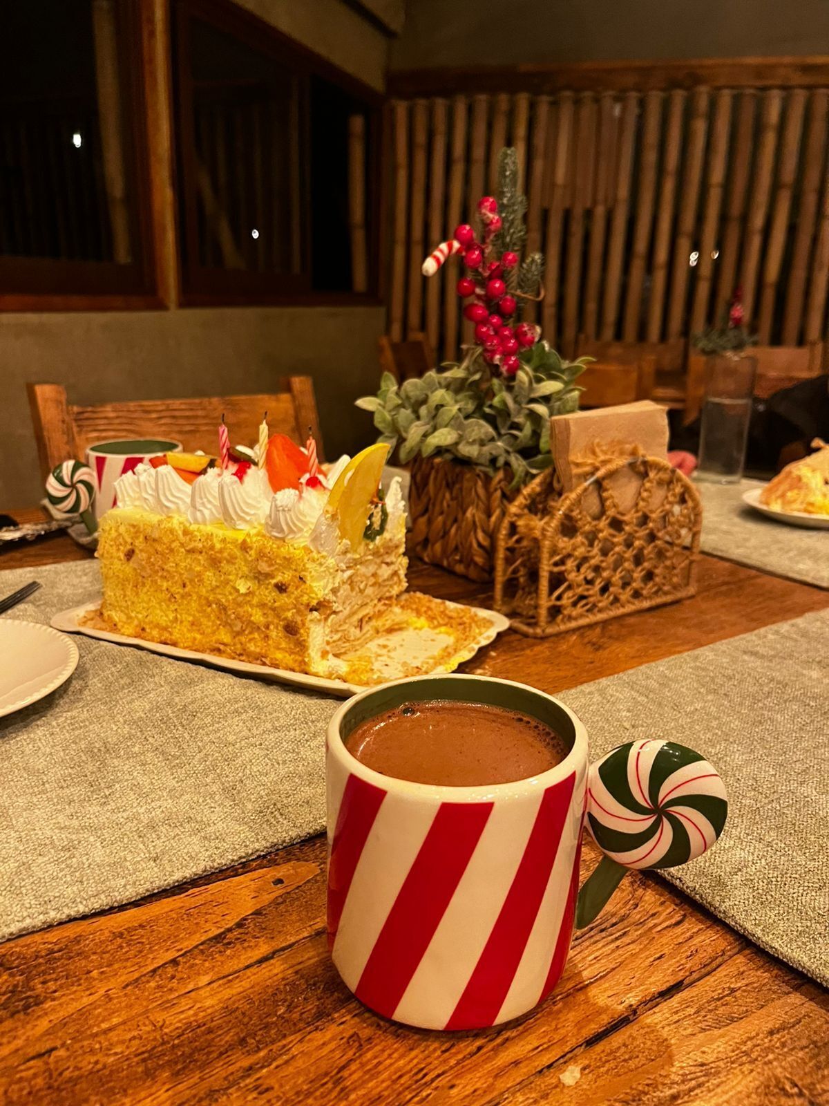 A table with a slice of cake, a mug, and a decorative plant.