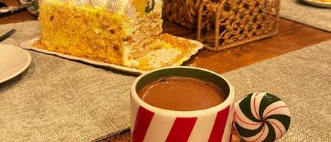 A table with a slice of cake, a mug, and a decorative plant.