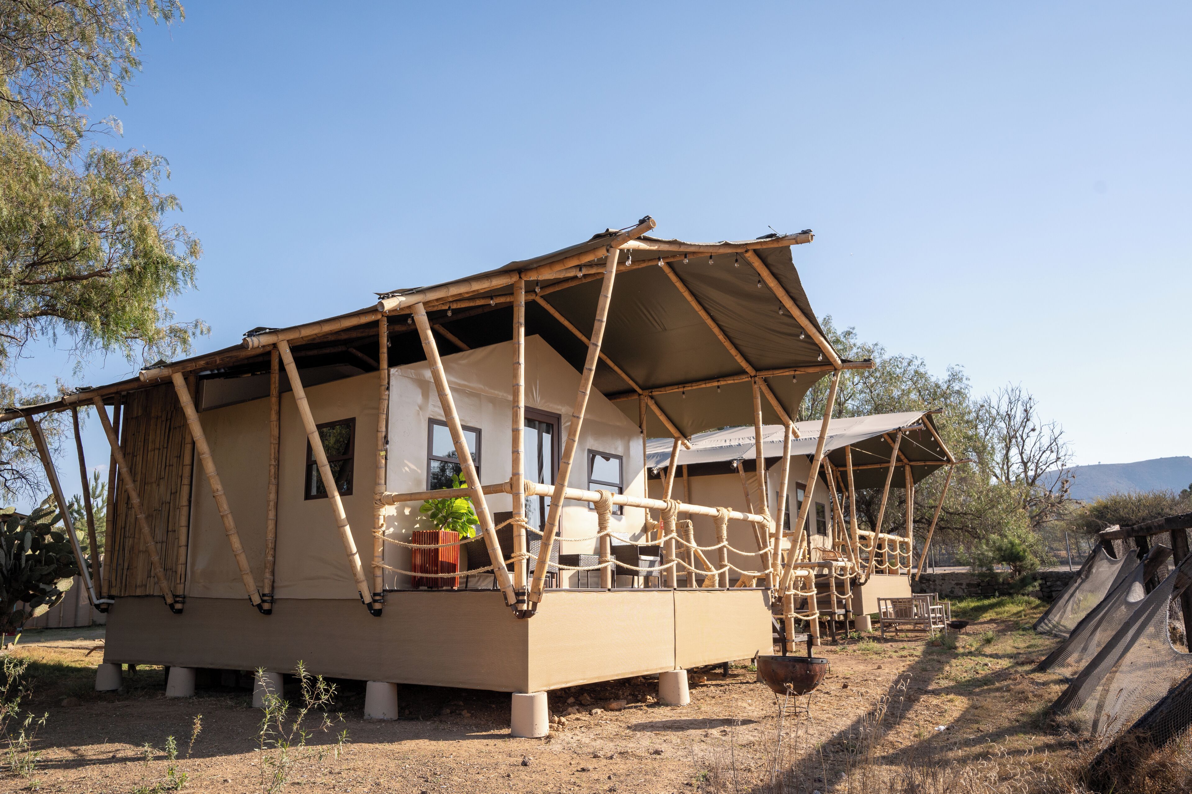 A rustic, single-story building with a covered porch, a small garden area, and a slide.