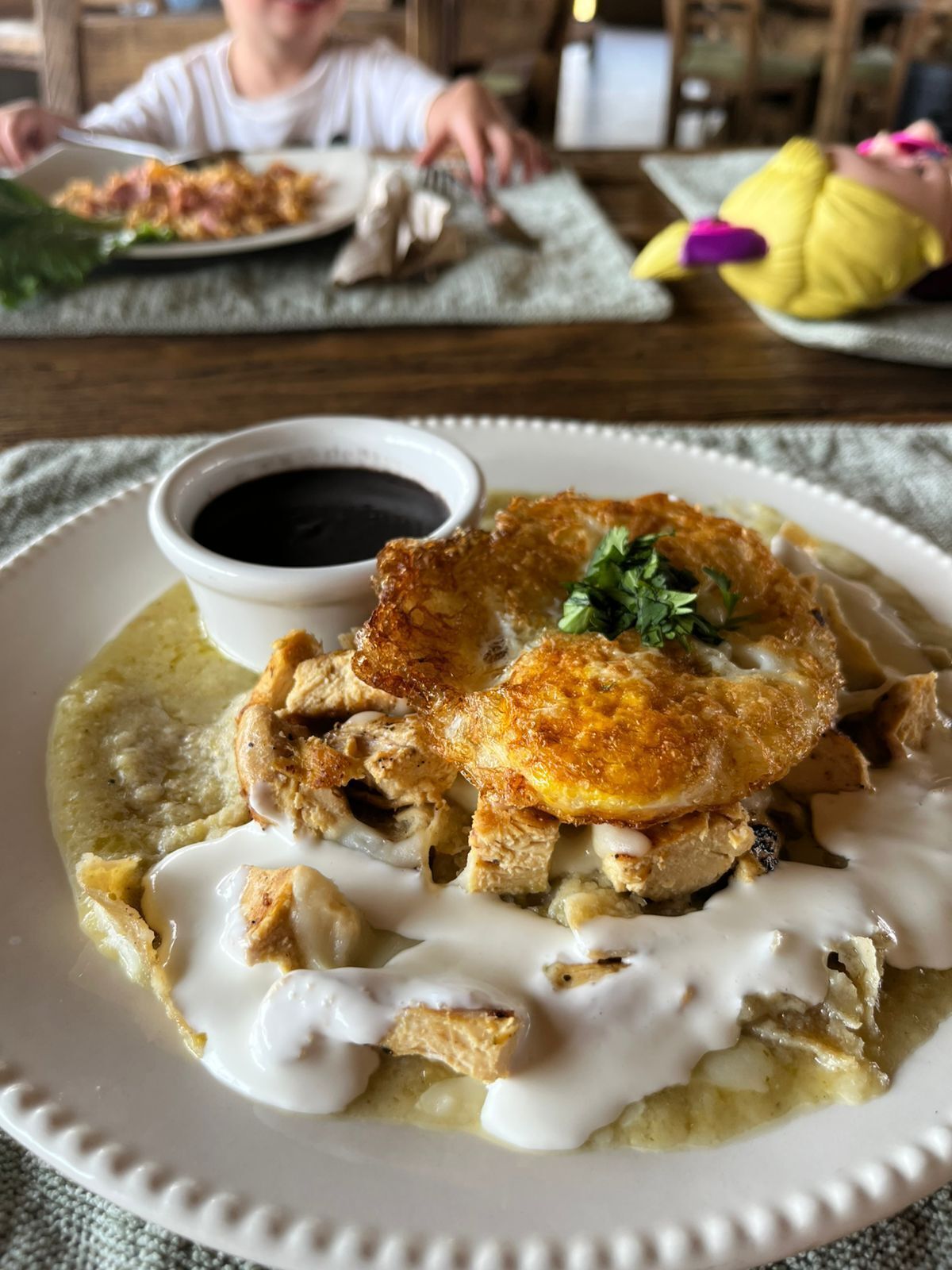 A plate of food with a creamy sauce and a small bowl of sauce on the side.