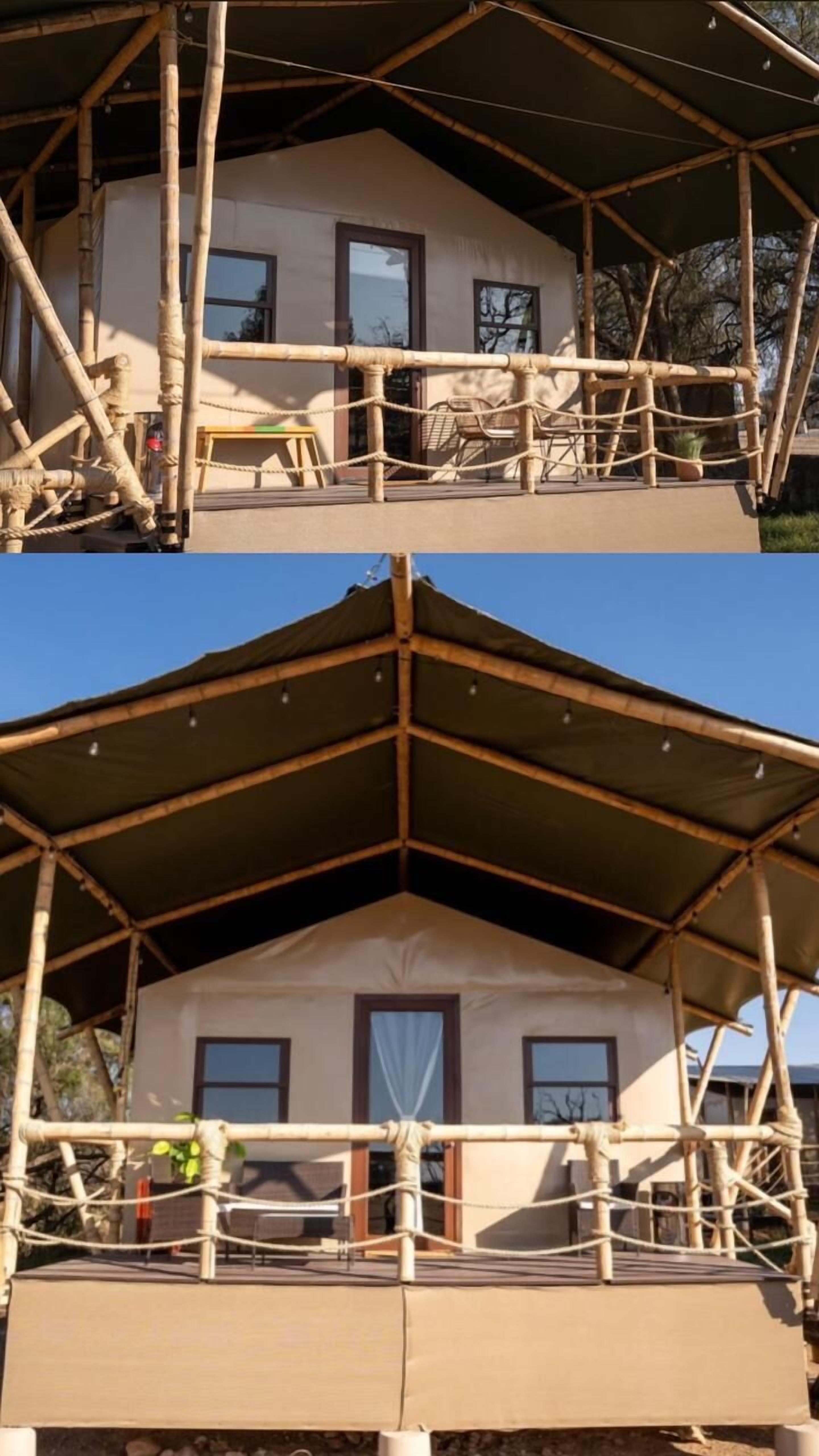 Een bamboestructuur met twee verdiepingen en een overdekt balkon, dat schaduw biedt en uitzicht geeft op de omgeving.