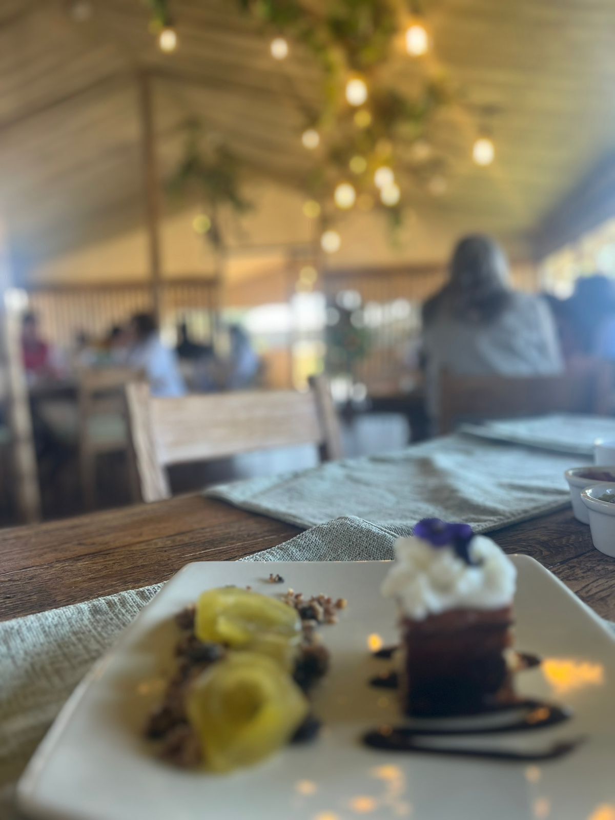Een eettafel met een dessertbord, een servet en een kop.