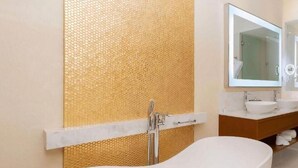 Une salle de bain moderne avec une baignoire sur pieds, un grand miroir et un meuble-lavabo en bois.