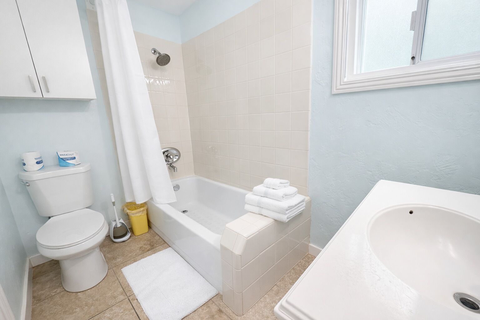 A bathroom with a toilet, a bathtub, a shower, and a sink.
