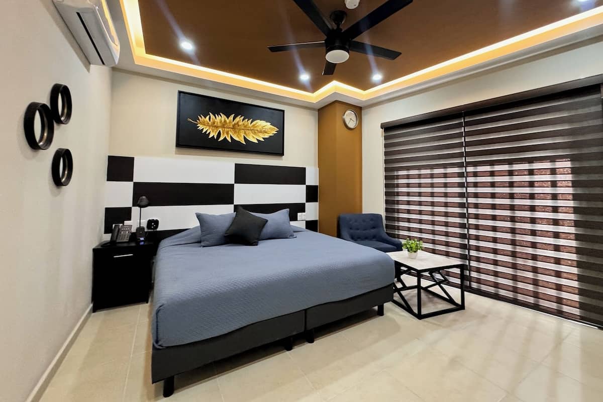 A modern bedroom with a bed, bedside table, and a ceiling fan.
