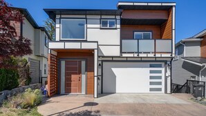 A modern two-story house with a garage, large windows, and a well-maintained front yard. - Marvelous Home In Victoria, BC (Langford)