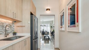 Una cucina moderna con mobili in legno, frigorifero in acciaio inox e piano di lavoro in granito.