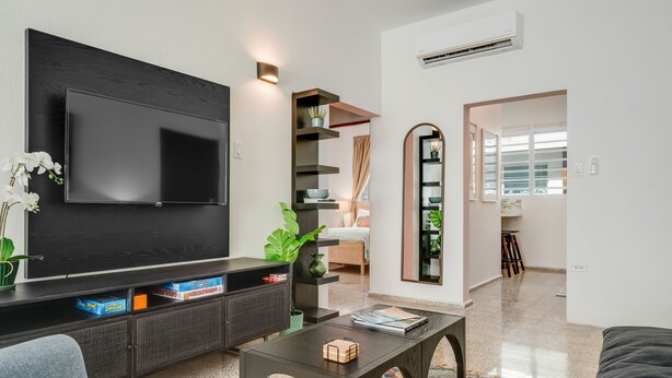 Un soggiorno moderno con una TV a schermo piatto, un divano, un tavolino da caffè e una libreria.