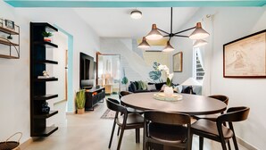 A modern dining area with a round table, dark chairs, and pendant lighting. - Stylish Apartment in Condado (San Juan)