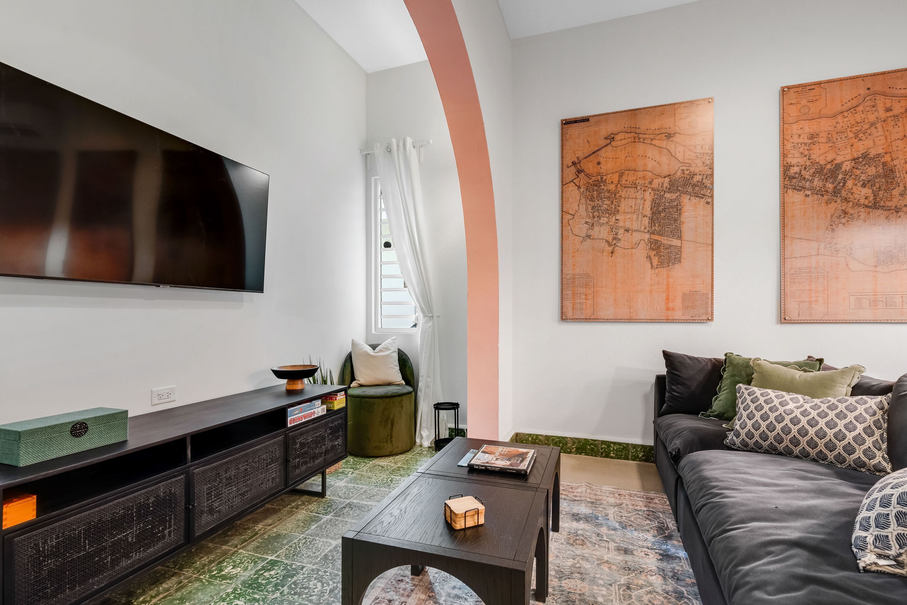 A modern living room with a flat-screen TV, a sofa, a coffee table, and a console table with decorative items.