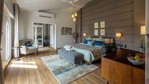Een moderne slaapkamer met een groot bed, nachtlampjes, een houten dressoir en uitzicht op de omgeving.