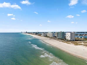 A coastal hotel with multiple high-rise buildings, a sandy beach, and a clear view of the ocean. - Warm Winter Escape, Spacious 4BR Home, Pool, Walk to the Beach! (Pensacola)