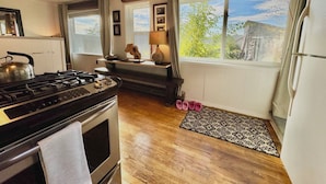 A kitchen with a stove, oven, and a window with a view of greenery. - Sunset Ridge, Near Downtown, Hot tub, Outdoor Living, all with Panoramic View,  (Spokane)