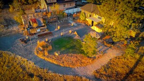 An aerial view of a residential area with houses, a pond, and a fire pit area. - Sunset Ridge, Near Downtown, Hot tub, Outdoor Living, all with Panoramic View,  (Spokane)