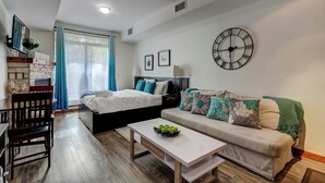 Een moderne, goed verlichte kamer met een bed, bank en een eethoek.