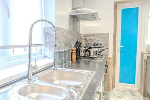 Een microgolfoven, een oven, een blender, kookgerei, borden en bestek