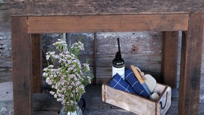 A rustic wooden wall with a white sink mounted on a wooden table.