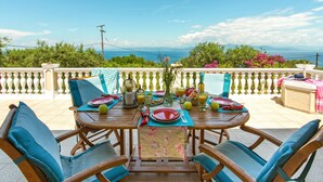 A wooden table set for a meal with a view of the sea. - Discover peace at Villa Kyklamino – your perfect Paxos escape (Gaios)