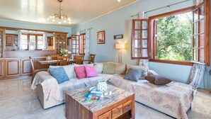 A spacious living area with a sofa set, a coffee table, and a dining table with chairs. - Discover peace at Villa Kyklamino – your perfect Paxos escape (Gaios)