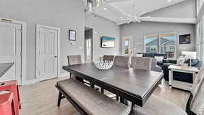 Un espace repas moderne avec une table en bois foncé, des chaises à revêtement gris et un bol décoratif blanc.