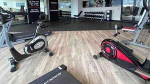 A modern gym with treadmills, elliptical machines, and weight benches. - F9 Brand NewSuite Delux Gym Pool Saune  (Santo Domingo)