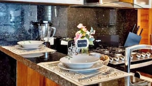 A kitchen with a granite countertop, a gas stove, and a coffee maker. - F9 Brand NewSuite Delux Gym Pool Saune  (Santo Domingo)