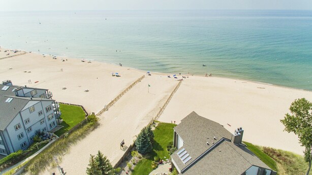 Une plage avec un bâtiment au premier plan et une vue dégagée sur la mer.