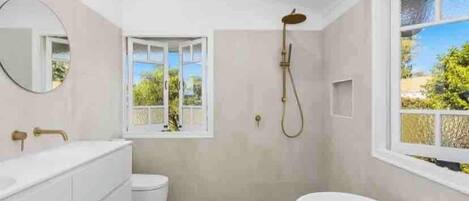 A modern bathroom with a freestanding bathtub, a toilet, and a shower.