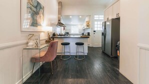 A modern kitchen with a central island, stainless steel appliances, and a glass bar counter. - Urban Getaway Top Floor - 4BR/4BA, Sauna, Ipswich (Newtown)
