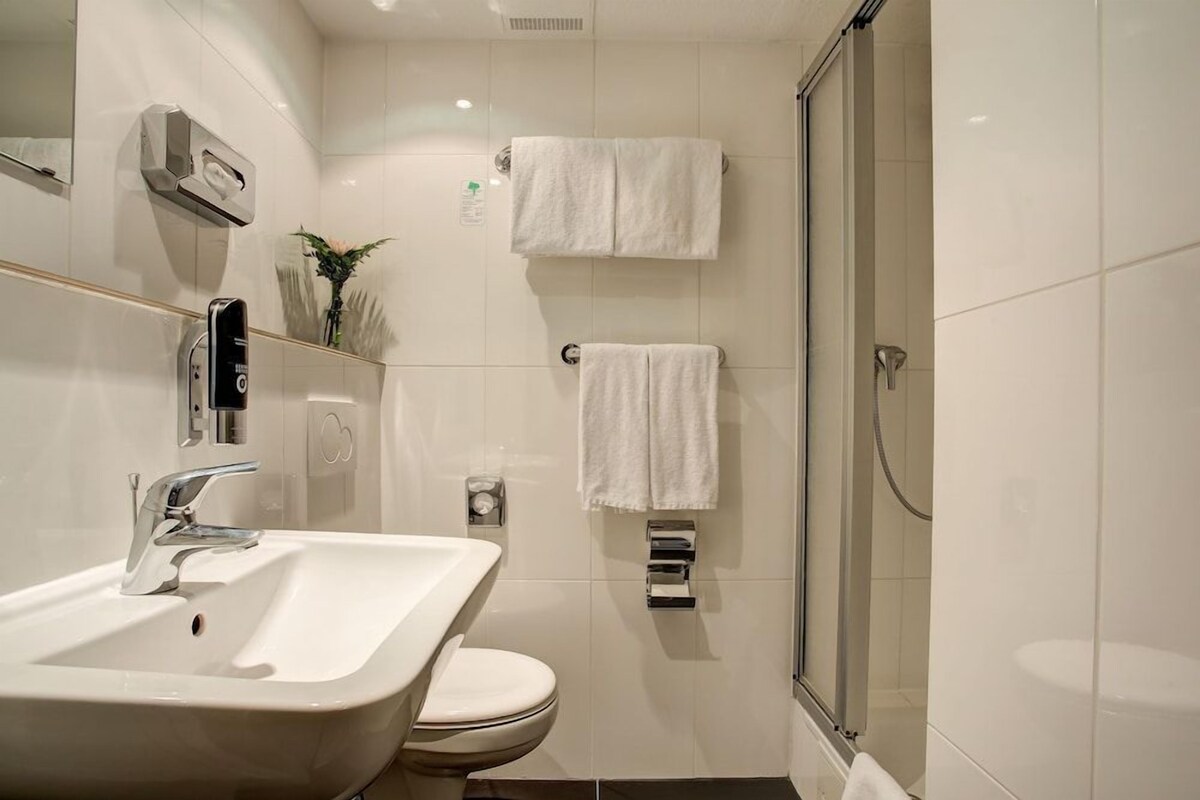 A bathroom with a sink, toilet, and shower.