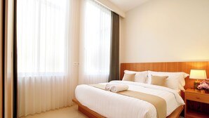 A hotel room with a large bed, a wooden headboard, a nightstand with a lamp, and sheer curtains. - Brand New Villa Tentrem 2 Canggu  (Canggu)