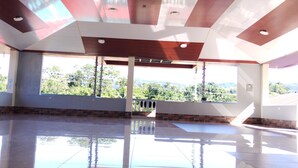 Un interior espacioso con techo alto, ventanas grandes y suelo reflectante.