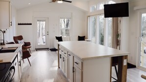 A modern kitchen with a central island, wooden cabinets, and a ceiling fan. - Farm Stay with Highland Cows (Mulberry)